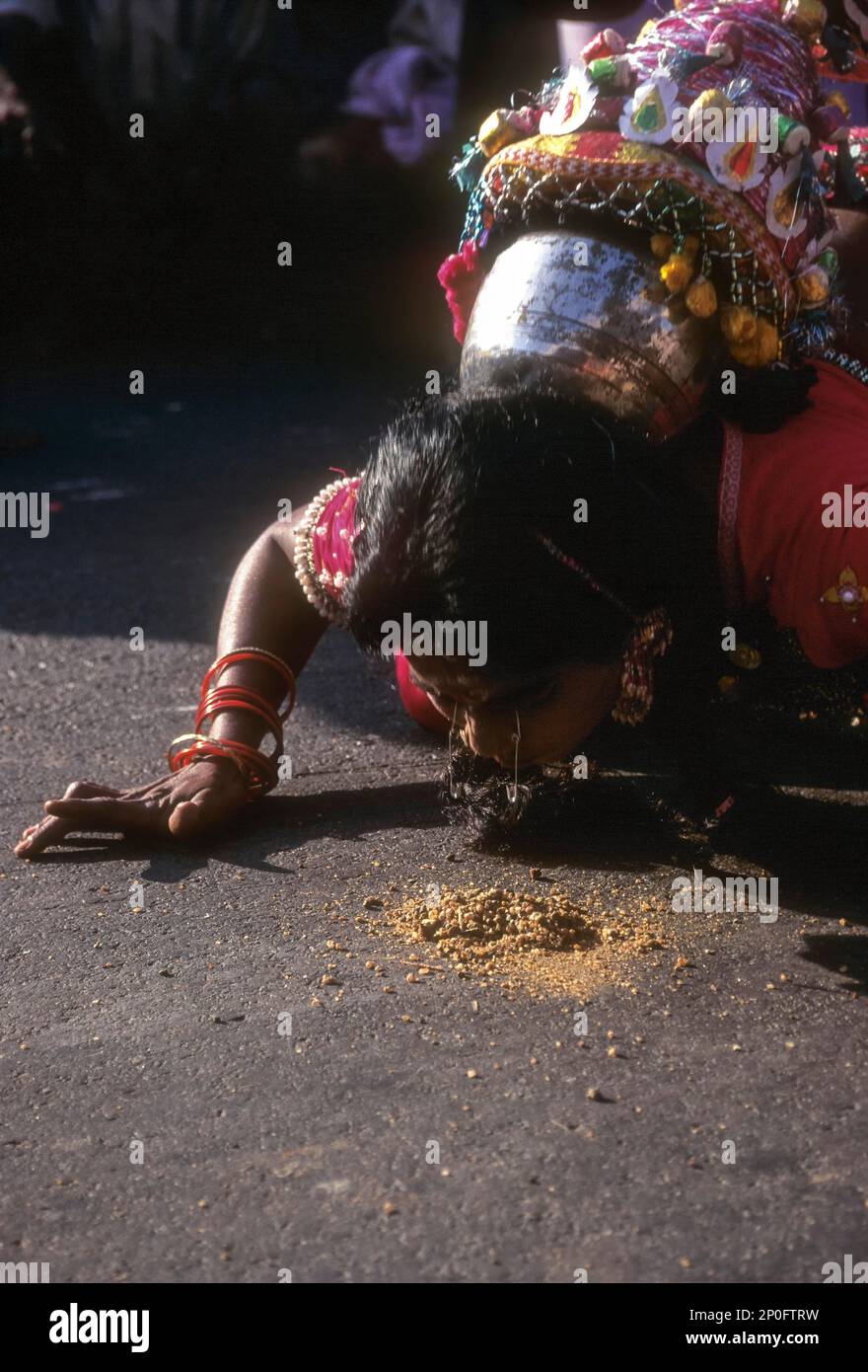 Une danseuse folklorique qui lève l'aiguille du sol à côté des yeux se hante lors de la célébration du festival Pongal à Madurai, Tamil Nadu, Inde Banque D'Images