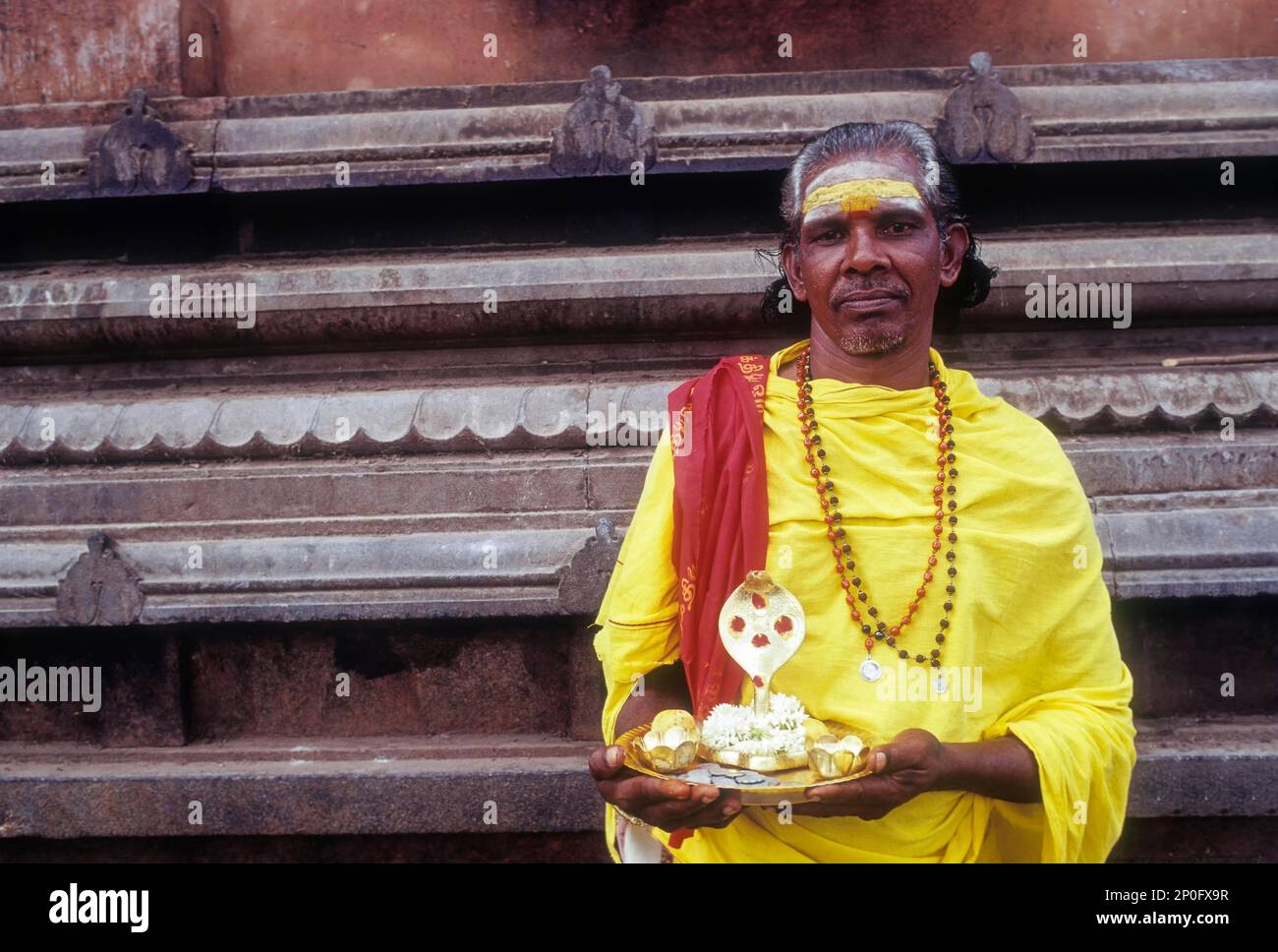 V. Moorthy – mendiant debout avec l'idole naga, temple de Lord Murugan à Palani près de Coimbatore, Tamil Nadu, Inde Banque D'Images