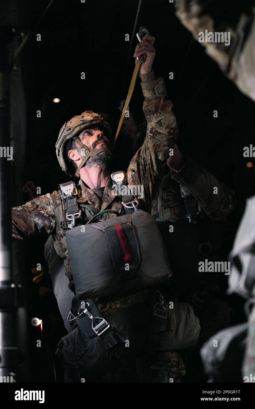 Un parachutiste de l'armée italienne avec la Brigade parachutiste Folgore accrochent sa ligne statique dans un avion Hercules C-130 au cours d'une opération aérienne avec les États-Unis Parachutistes de l'armée de la Brigade aéroportée 173rd à la zone de Juliet Drop, Pordenone, Italie, 26 janvier 2023. La Brigade aéroportée de 173rd est la U.S. La Force de réaction en cas d'urgence de l'armée en Europe, fournissant des forces rapidement déployables aux États-Unis les domaines de responsabilité de l'Europe, de l'Afrique et du Commandement central. Déployée en Italie et en Allemagne, la brigade s’entraîne régulièrement aux côtés des alliés et partenaires de l’OTAN pour construire des partenariats A. Banque D'Images