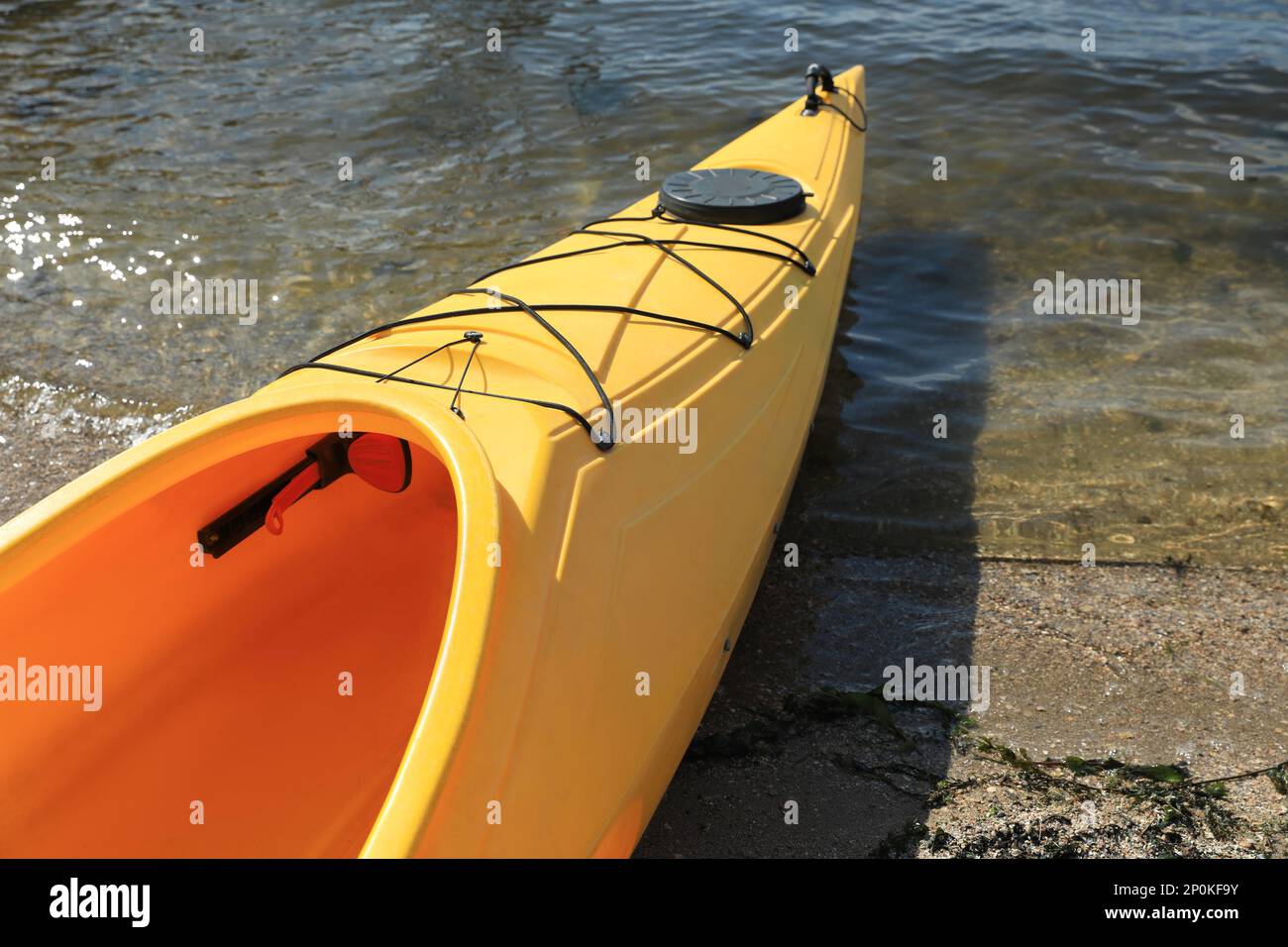 Kayak jaune sur la plage près de la rivière, à proximité. Activité de camp d'été Banque D'Images Kayak jaune sur la plage près de la rivière, à proximité. Activité de camp d'été Banque D'Images