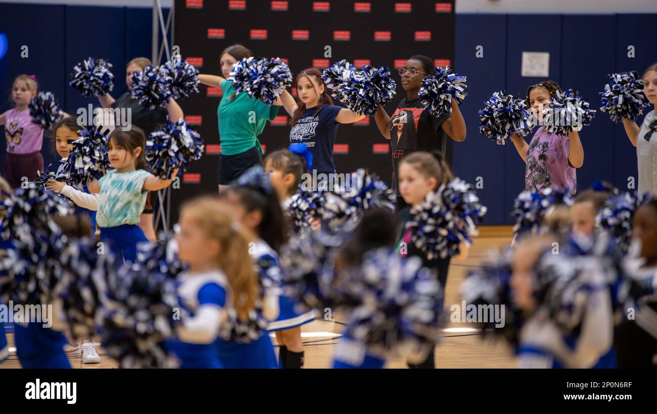Les enfants de la Marine corps Air Station Iwakuni exécutent une routine d'encouragement avec des cheerleaders professionnels de la National football League lors de la Pro Blitz Cheer Clinic sur MCAS Iwakuni, Japon, 12 février 2023. La visite éclair des forces armées Entertainment Pro permet aux membres du service déployés à l'avance et à leurs familles de rencontrer les meneurs et les joueurs de la NFL. Banque D'Images