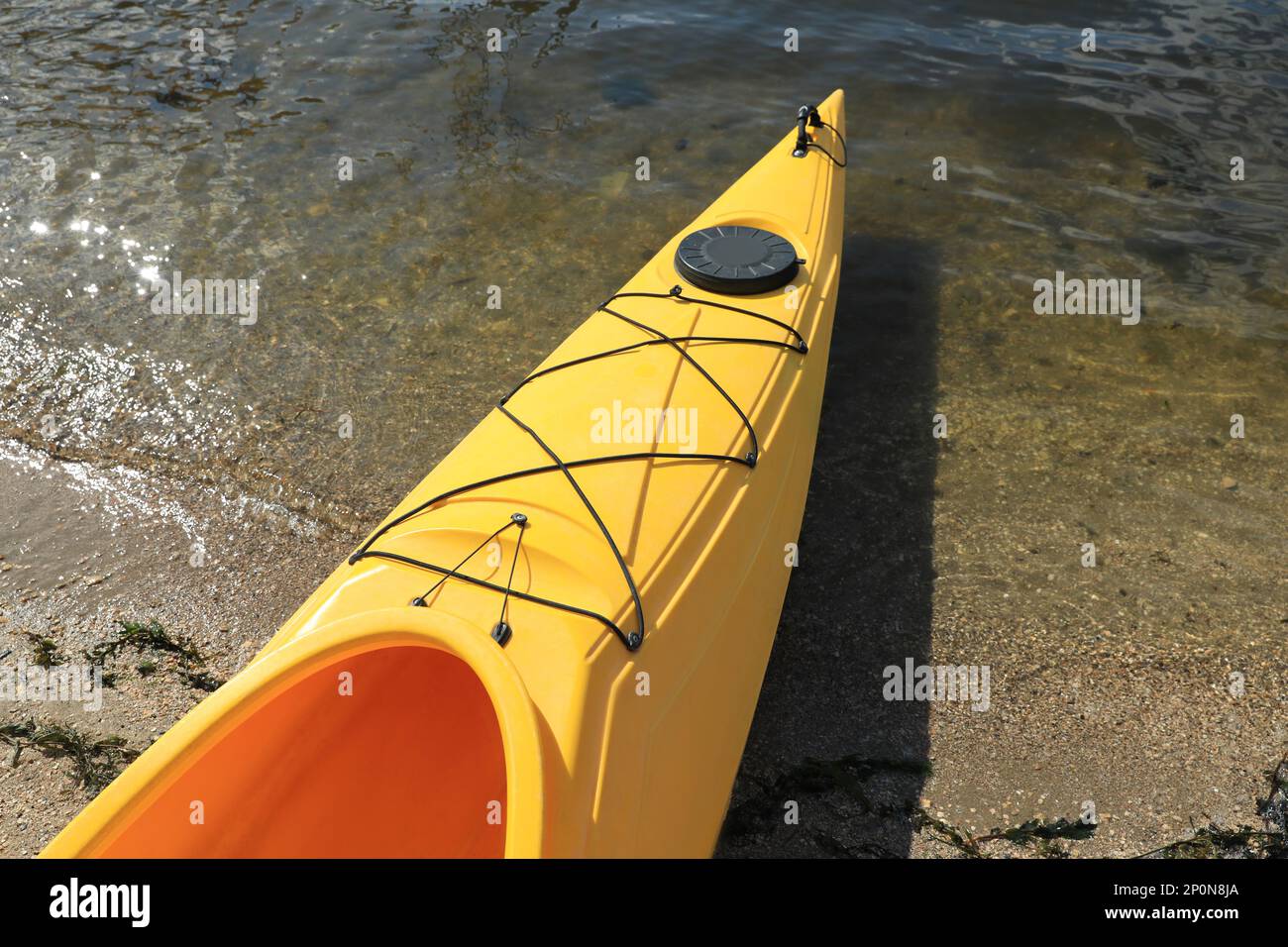 Kayak jaune sur la plage près de la rivière, à proximité. Activité de camp d'été Banque D'Images Kayak jaune sur la plage près de la rivière, à proximité. Activité de camp d'été Banque D'Images