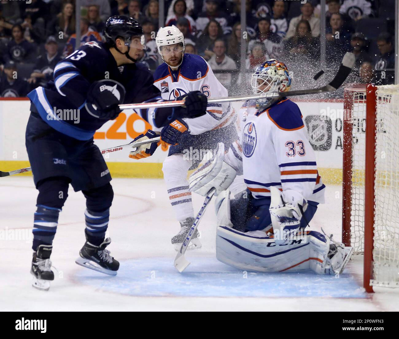 Winnipeg Jets' Brandon Tanev (13) knocks the puck into the net behind