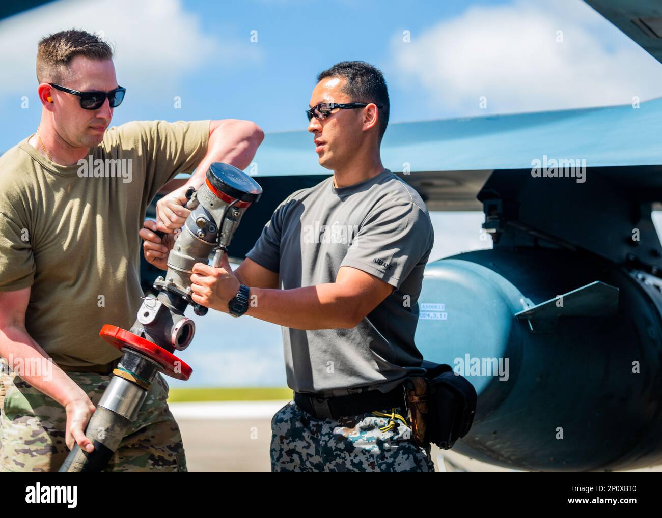 A ÉTATS-UNIS Un aviateur passe un tuyau de carburant à un membre de la Force aérienne d'autodéfense du Japon pendant le ravitaillement d'un Mitsubishi F-15J Eagle pendant le COPE North 2023 à la base aérienne d'Andersen, Guam, le 6 février 2023. Des exercices comme COPE North permettent aux forces aériennes du Pacifique de valider de nouvelles façons de déployer et de manœuvrer les biens. Banque D'Images