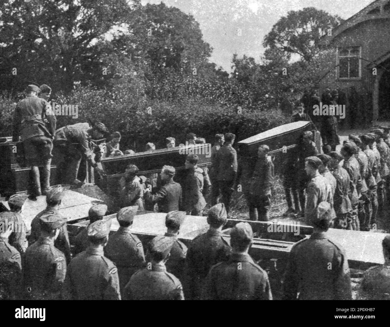 'Le Zeppelin Abattu; dans la banlieue Nord de Londres; Funeraillesmilitaires faits par les Anglais aux saisires hommes de l'équipement ennemi: Départ de l'eglise de Cuffley et descente des ceruieils dans la fosse', 1916. De "Collection de la guerre IV L'Illustration Tomé CXLVIII. La guerre Juillet, Aout, septembre, octobre, novembre, Décembre 1916". Banque D'Images