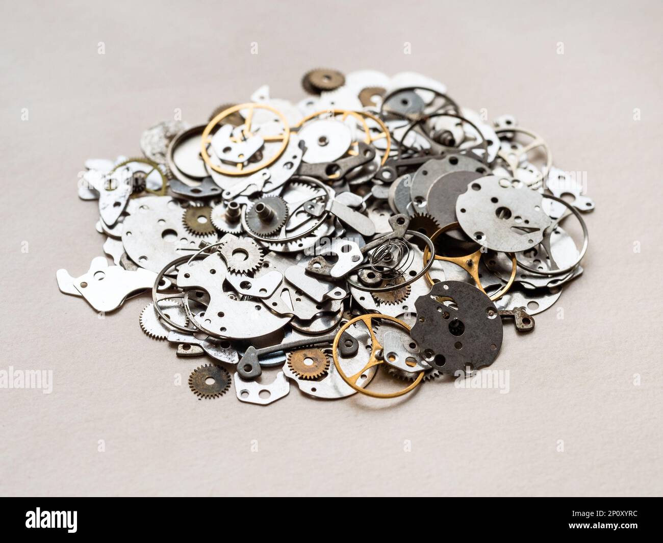 pile de différentes anciennes pièces de rechange pour montres mécaniques gros plan sur une table en bois dans l'atelier horloger Banque D'Images