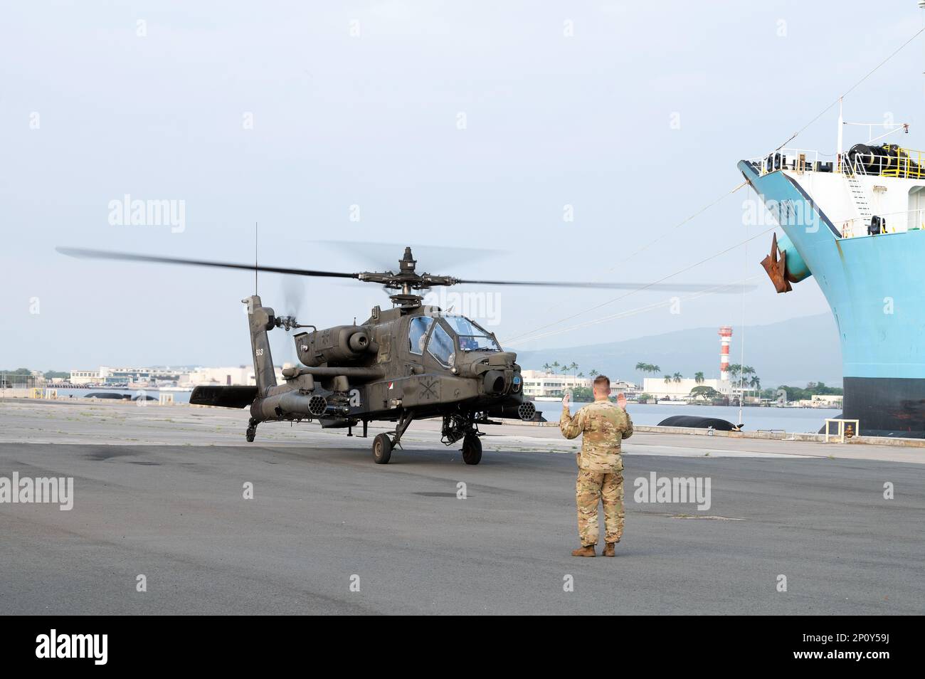 A ÉTATS-UNIS Un soldat de l'armée affecté à la division d'infanterie de 25th dirige un Apache AH-64 vers son emplacement de stationnement sur les jetées de la base conjointe Pearl Harbor-Hickam, le 10 janvier 2023. Les préparatifs sont en cours pour le 25th ID lorsqu'ils transportent des hélicoptères à bord des États-Unis Des navires de la Marine pour soutenir divers exercices d'entraînement dans l'Indo-Pacifique, y compris Cobra Gold 2023. Cet événement annuel organisé en Thaïlande augmente la capacité, la capacité et l'interopérabilité des pays partenaires tout en renforçant notre engagement en faveur d'une Indo-Pacific libre et ouverte. Banque D'Images