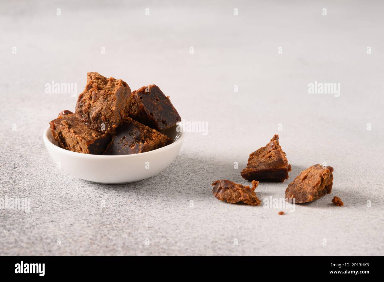 Kithul jaggery et sirop de mélasse sucré naturel dans un bol blanc sur fond gris. Copier l'espace. Gros plan. Sucre alternatif. Faible niveau de GI alimentaire. Super-nourriture . Banque D'Images