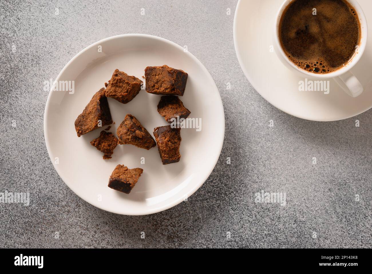 Kithul jaggery et sirop de mélasse sucré naturel dans un bol sur fond gris. Vue de dessus. Sucre de remplacement et superaliment à faible indice glycémique. PAL Banque D'Images