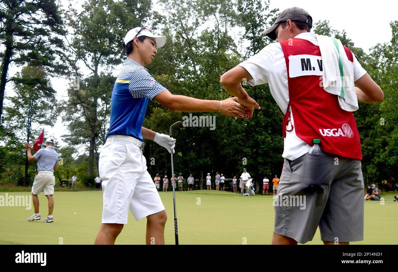 Australia's Min Woo Lee, front left, is congratulated by his caddie, Reid Smith, after a shot that landed close to the 35th hole as opponent Noah Goodwin, back left. claps on the final day of the U.S. Junior Amateur golf tournament in Ooltewah, Tenn., Saturday, July 23, 2016. (Robin A. Rudd/Chattanooga Times Free Press via AP) Banque D'Images