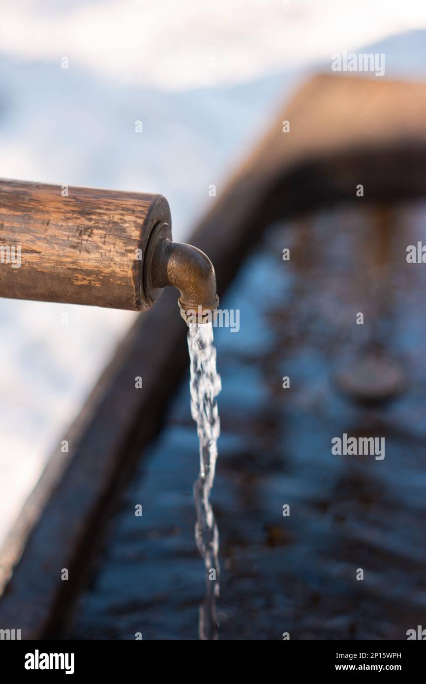 De l'eau potable courante propre à partir d'un robinet de fontaine en forêt en hiver en Suisse. Banque D'Images