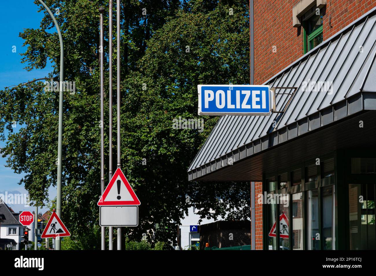 Panneau sur le bâtiment de la police. Panneaux routiers en arrière-plan sur la rue. Banque D'Images