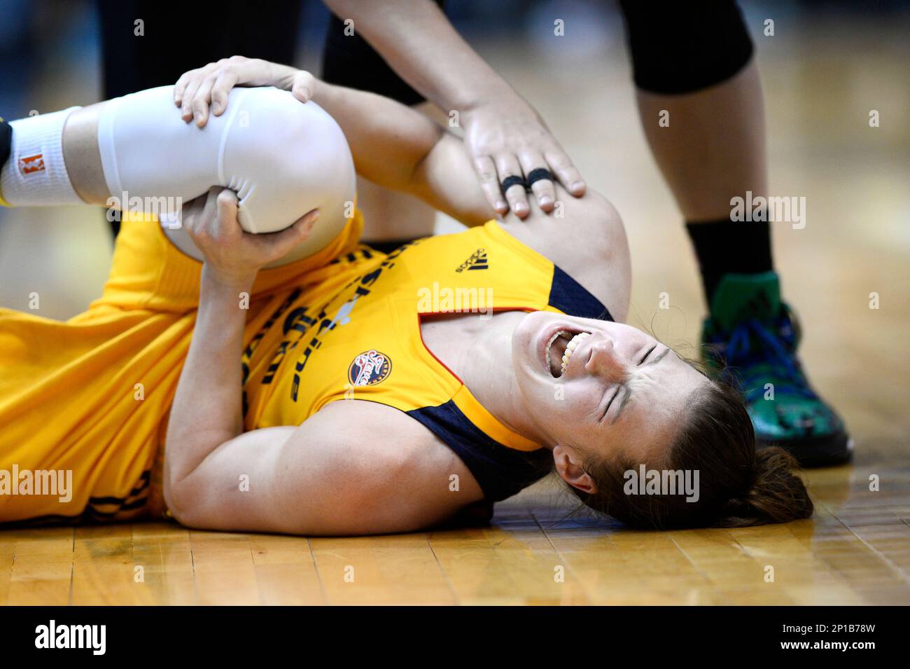 Indiana Fever guard Maggie Lucas grabs her knee in pain after an injury while guarding Minnesota