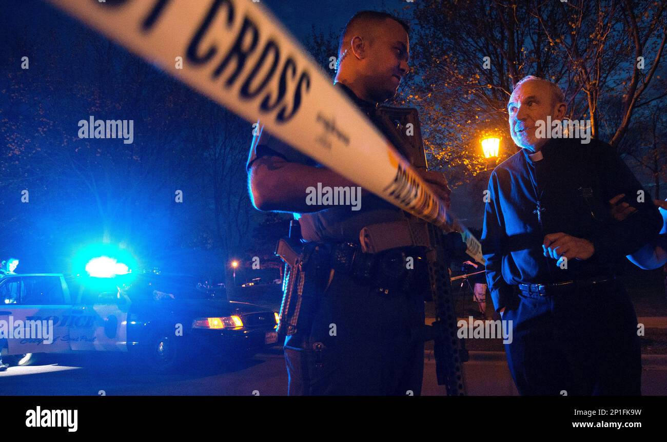 In this photo taken April 17, 2016, the Rev. Lawrence Hubbard, right, speaks with a St. Paul police officer near the scene of a shooting that took place at Indian Mounds Regional Park in St. Paul. Police spokesman Steve Linders said Monday, April 18, 2016, a 24-year-old Minneapolis man has been booked on suspicion of homicide.(Carlos Gonzalez/Star Tribune via AP) MANDATORY CREDIT; ST. PAUL PIONEER PRESS OUT; MAGAZINES OUT; TWIN CITIES LOCAL TELEVISION OUT Banque D'Images