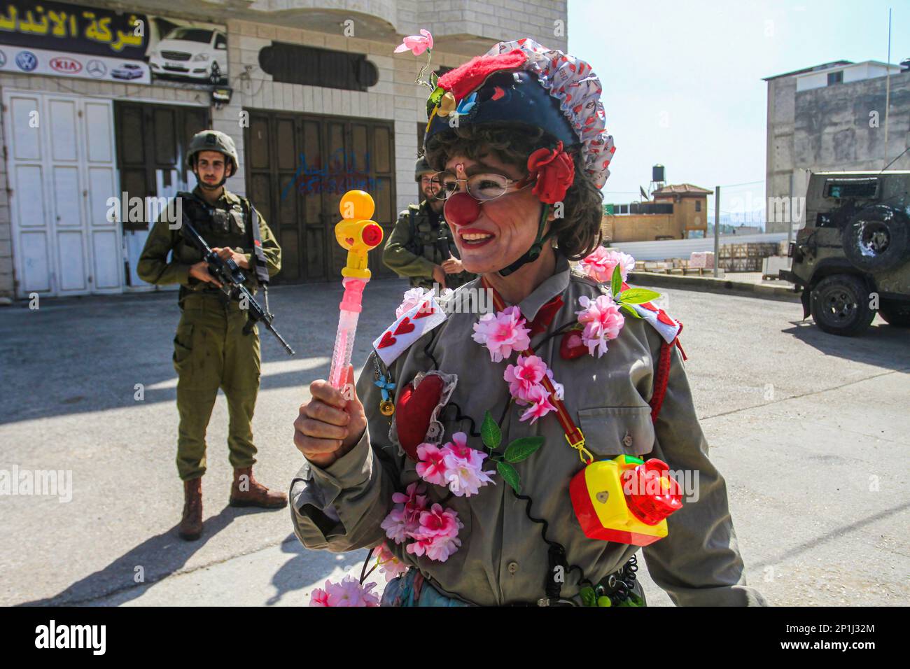Naplouse, Palestine. 03rd mars 2023. Un activiste israélien habillé comme un clown joue devant une patrouille à pied de soldats israéliens dans la ville de Hawara, au sud de Naplouse, en Cisjordanie occupée. Crédit : SOPA Images Limited/Alamy Live News Banque D'Images