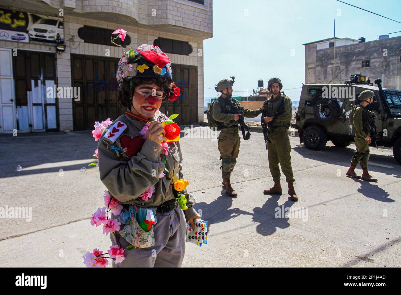 Naplouse, Palestine. 03rd mars 2023. Un activiste israélien habillé comme un clown joue devant une patrouille à pied de soldats israéliens dans la ville de Hawara, au sud de Naplouse, en Cisjordanie occupée. (Photo de Nasser Ishtayeh/SOPA Images/Sipa USA) crédit: SIPA USA/Alay Live News Banque D'Images