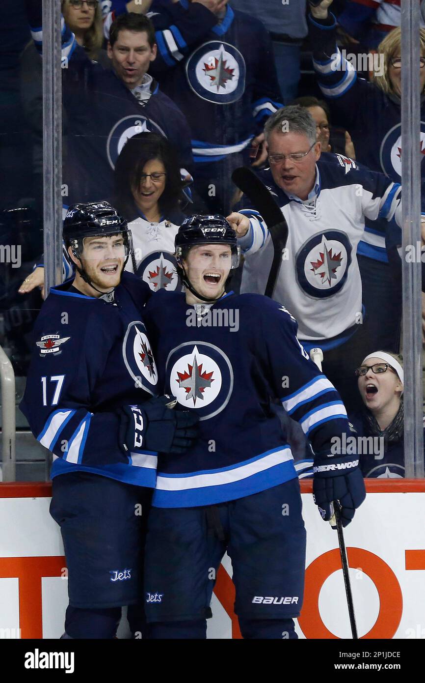 Winnipeg Jets' Adam Lowry (17) and Jacob Trouba (8) celebrate Lowry's goal against the Los Angeles Kings during the second period of an NHL hockey game Thursday, March 24, 2016, in Winnipeg, Manitoba. (John Woods/The Canadian Press via AP) Banque D'Images