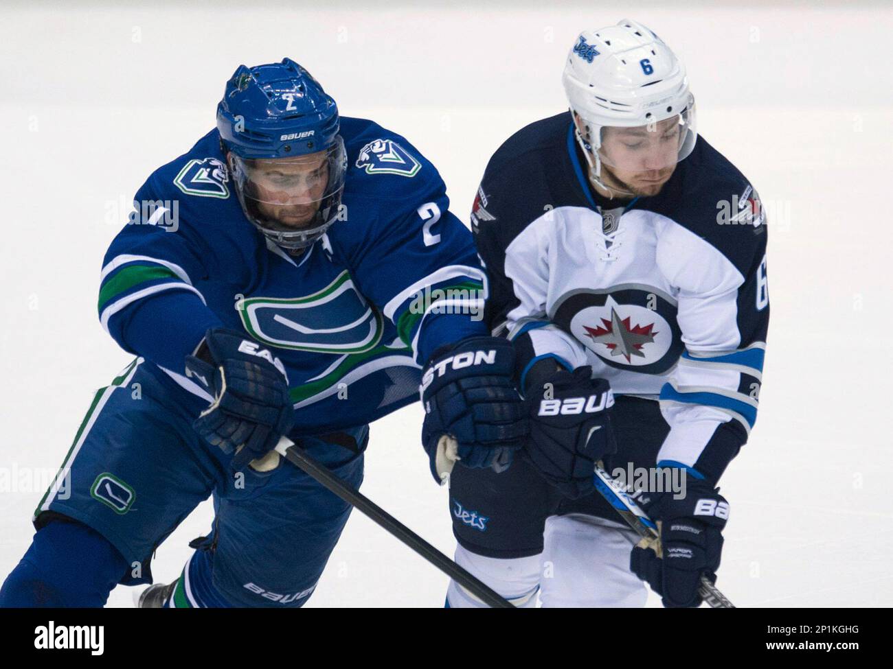 Vancouver Canucks defenceman Dan Hamhuis (2) fights for control of the puck with Winnipeg Jets centre Alexander Burmistrov (6) during second period NHL hockey action in Vancouver, British Columbia, on Monday, March 14, 2016. (Jonathan Hayward/The Canadian Press via AP) Banque D'Images