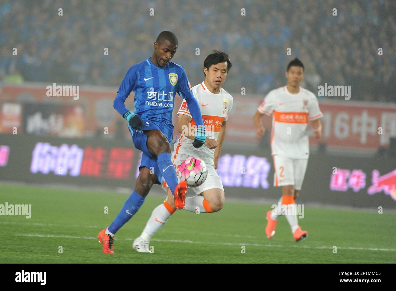Jiangsu Suning's Ramires, left, fights for the ball against Shandong Luneng's Hao Junmin, center, during a Chinese Super League soccer match in Nanjing in east China's Jiangsu province on Saturday, March 5, 2016. Jiangsu Suning beat Shandong Luneng 3-0 on Saturday.(Photo By Jason Liu/Color China Photo/AP Images) Banque D'Images