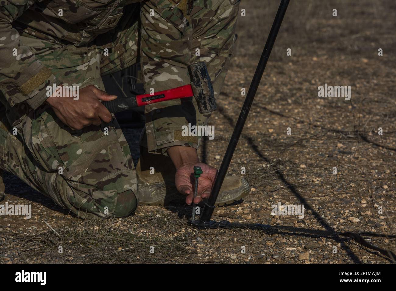 ÉTATS-UNIS Tech. De la Force aérienne Le Sgt. Paris Bell, 435th, chef d'aérodrome de l'Escadron d'intervention en cas d'urgence, pousse un pieu dans le sol pour fixer un capteur météorologique pendant l'exercice à la poursuite de sol près de Saragosse, Espagne, le 2 février 2023. Chasing sol est un déploiement bilatéral d'entraînement en vol entre les forces aériennes américaines et espagnoles afin d'accroître l'interopérabilité entre les alliés de l'OTAN. Banque D'Images