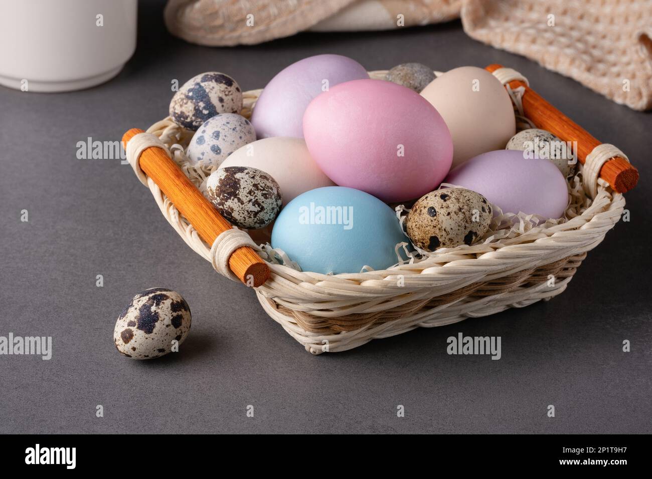 Panier avec œufs de pâques sur fond gris Banque D'Images