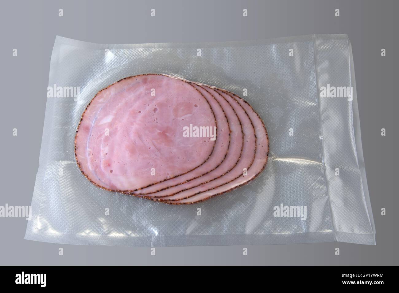 Tranches de jambon fumé aromatisées au poivre, rôti de porc en sachet sous vide pour cuire sous vide sur fond gris Banque D'Images