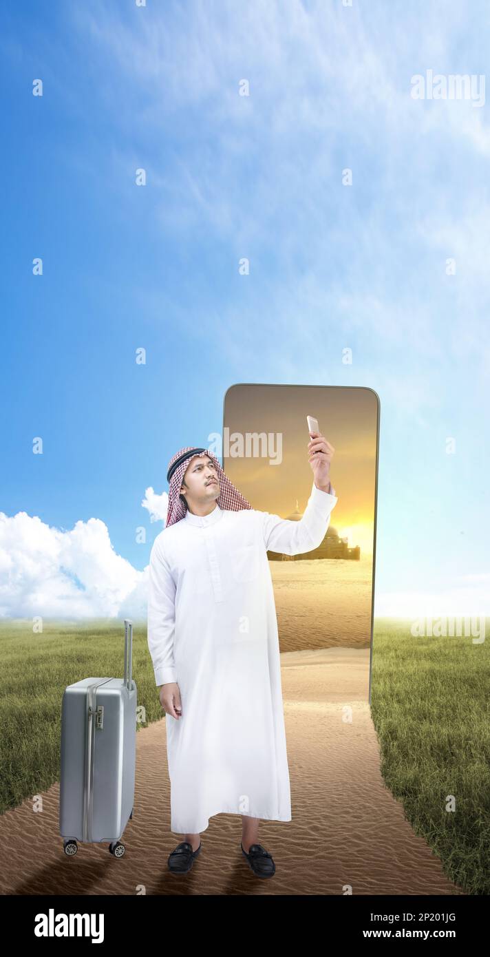 Homme arabe portant le keffiyeh regardant le téléphone portable en dehors de l'écran du téléphone portable Banque D'Images