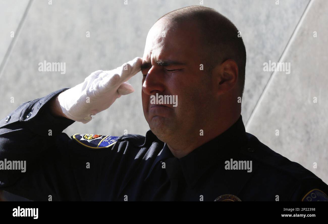 A Downey police officer salutes the casket before the funeral for fellow Downey police officer Ricardo "Ricky" Galvez at the Cathedral of Our Lady of the Angels in downtown Los Angeles on Monday Nov. 30, 2015. He was shot to death near the suburban Downey Police Department on Nov. 18 in what authorities believe was a botched robbery attempt. Three suspects have been arrested and charged with murder. (Mark Boster/Los Angeles Times via AP, Pool) Banque D'Images