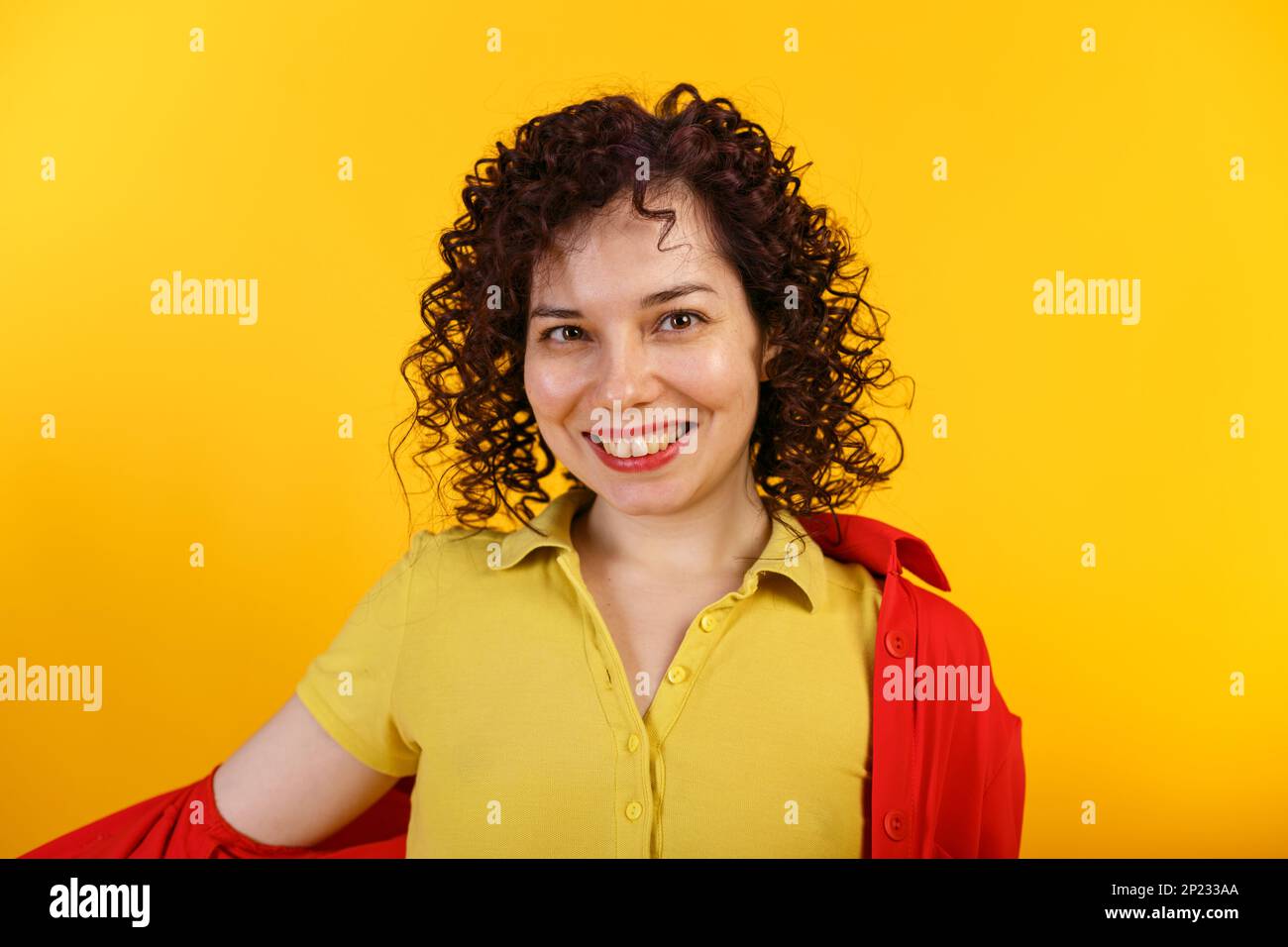 Photo de studio d'une jolie femme positive et souriante. Fille riante en chemise jaune vif. Isolé sur fond jaune. Gros plan. Copier l'espace Banque D'Images