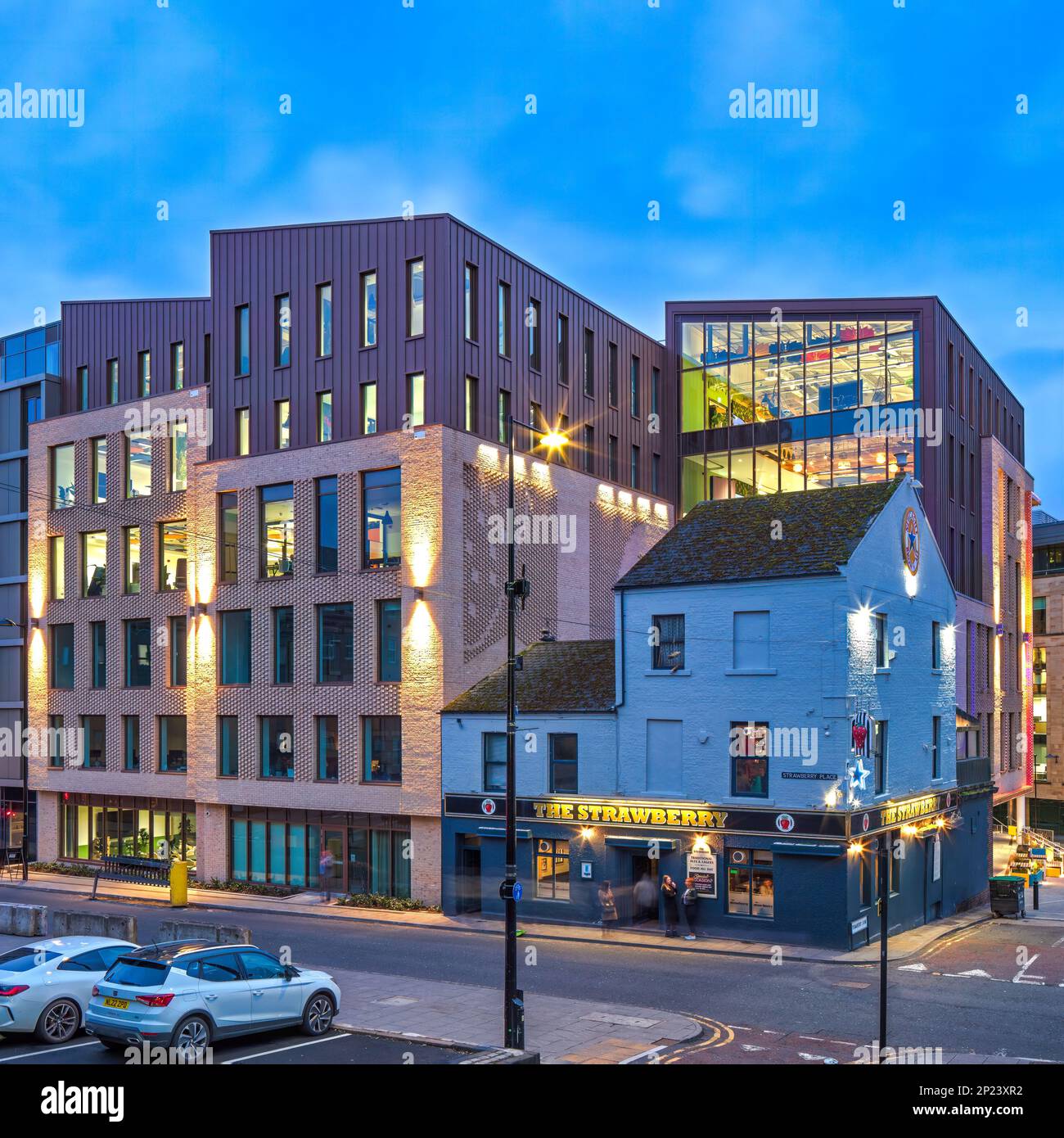 Vue architecturale externe au crépuscule sur One Strawberry Lane, Newcastle upon Tyne, avec le bâtiment éclairé à l'intérieur et éclairage extérieur Banque D'Images