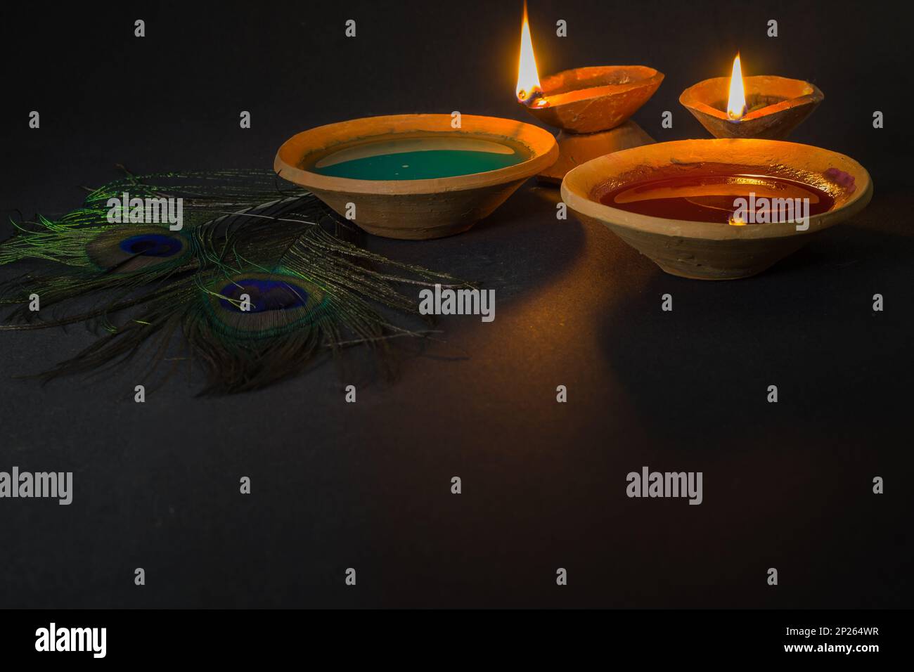 joyeux holi célébration avec des couleurs, une lampe d'argile et la plume de paon symbolisant le dieu hindou krishna. Holi ou dol yatra est largement célébré dans toute l'inde A. Banque D'Images