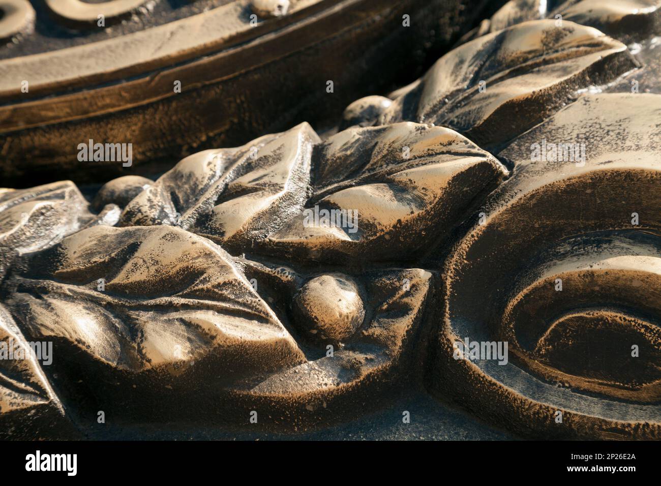 Couronne de laurier close-up bronze foncé metal cast arrière-plan. Feuilles et baies Vintage art sculpture détail Banque D'Images