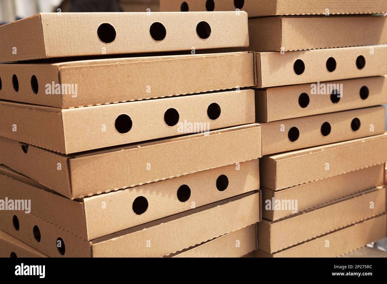 Deux piles de nouvelles boîtes à pizza fermé avec des trous. De nombreux cartons d'aliments vides télévision dans une pile. Beaucoup d'emballage brun dans un restaurant à emporter Banque D'Images