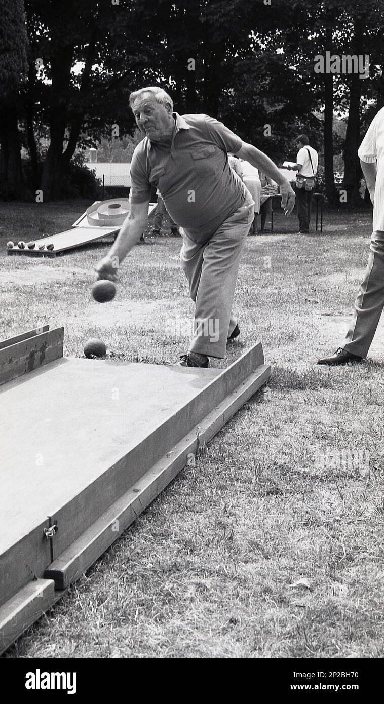 1989, historique, foire de campagne, boules, un homme âgé bowling une boule le long d'une rampe en bois, Angleterre, Royaume-Uni. Banque D'Images
