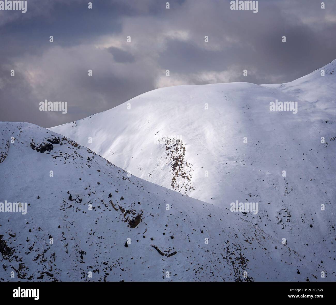 Une chaîne de montagnes à couper le souffle, avec de la neige dans le ciel d'hiver. Une vue grandiose de la beauté et de la grandeur des natures. Banque D'Images