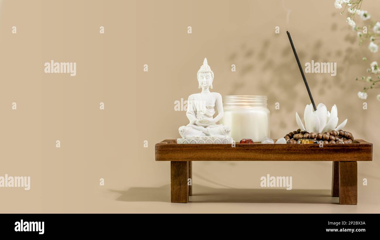 Soin de soi encore la vie avec Bouddha statue, bougie, bâton d'arôme sur le podium en bois. Procédure de rituel asiatique de spa. Concept de santé mentale, détente, yoga et Banque D'Images