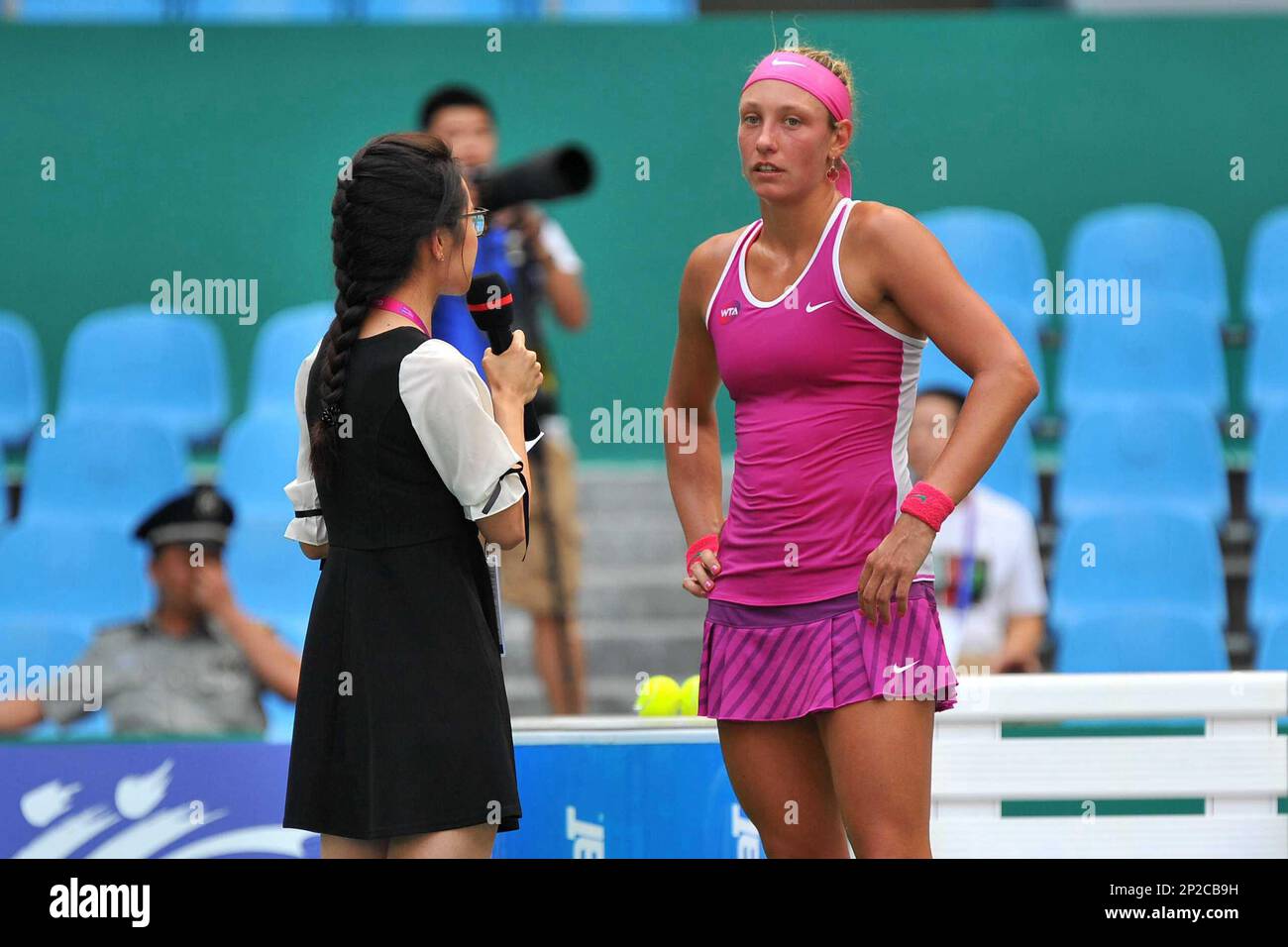 Yanina Wickmayer of Belgium, right, is interviewed after defeating Monica  Niculescu of Romania in their quarterfinal match of the women's singles  during the 2015 WTA Guangzhou Open tennis tournament in Guangzhou city,