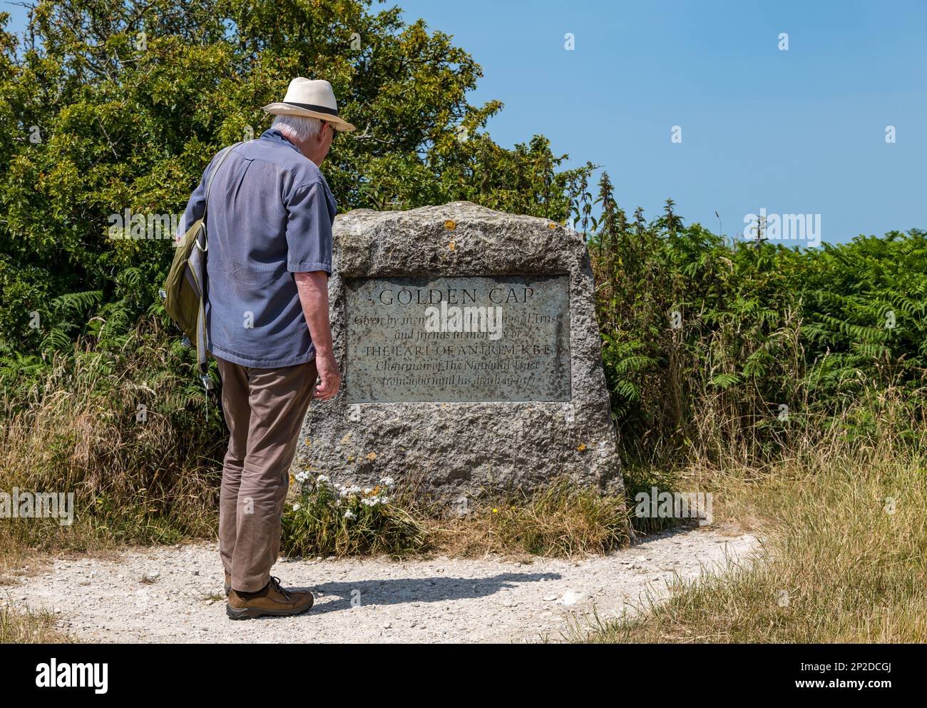 Un homme plus âgé portant un chapeau de Panama signe de lecture sur Golden Cap sur la côte jurassique, Dorset, Angleterre, Royaume-Uni Banque D'Images