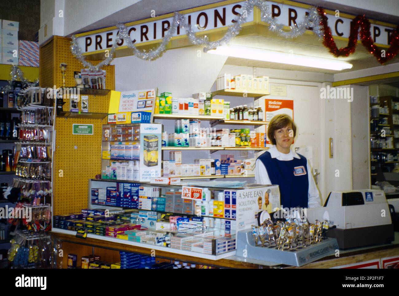 Pharmacie distributeur pharmacie comptoir femme travaillant par Till Surrey Angleterre Banque D'Images