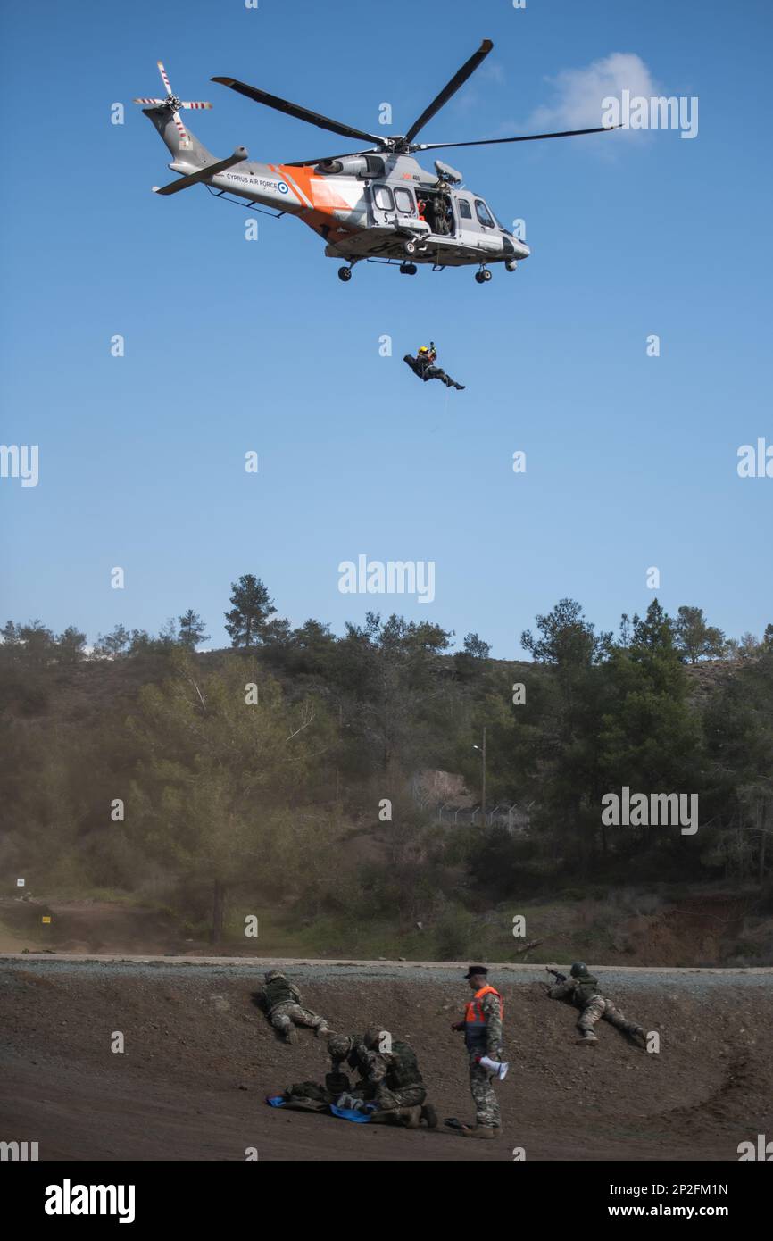 Les troupes chypriotes de la Brigade blindée de 20th traitent une victime simulée en utilisant la méthode de l'hémorragie massive, des voies aériennes, des respirations, de la circulation, des blessures à la tête/de l'hypothermie (MARS), qui a été formée avec les États-Unis Les parachutistes médicaux de l'armée affectés au 2nd Bataillon, 503rd Airborne Infantry Regiment, 173rd Airborne Brigade, en tant que parasauveurs chypriotes de l'escadron de recherche et de sauvetage 460th se repoussent d'un hélicoptère AW139 pour préparer la victime à une évacuation médicale aérienne lors d'un exercice tactique de soins aux victimes de combat à Larnaca, Chypre, 16 février. 2023, dans le cadre de l'exercice Silver Falcon 23. Si Banque D'Images