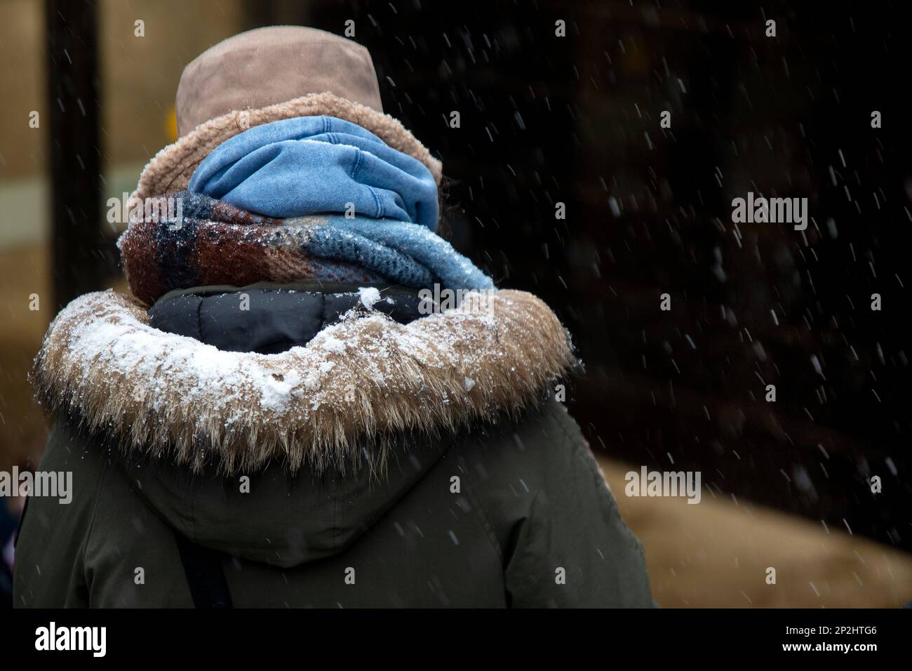 Une fille descend une rue enveloppée de foulards jusqu'à une station de métro dans le froid, le temps a chuté à Moscou, en Russie Banque D'Images