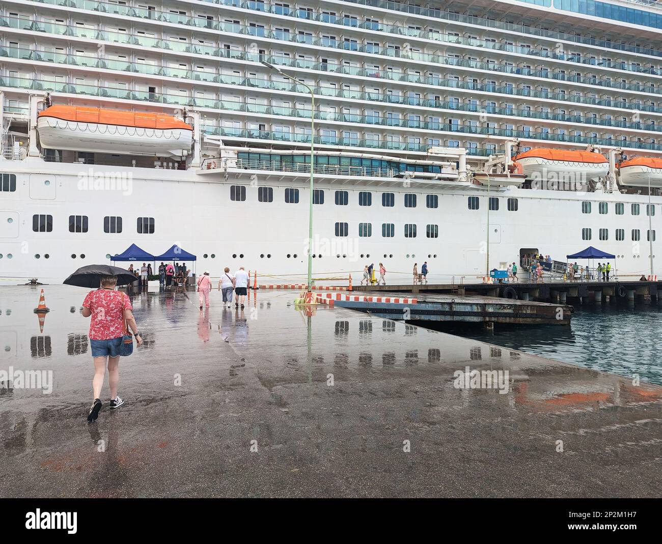 Des personnes marchant sur un quai sur le point d'embarquer sur le bateau de croisière P and O MV Britannia après le temps à terre à Kralendijk, Bonaire, Leeward Antilles, Caraïbes Banque D'Images