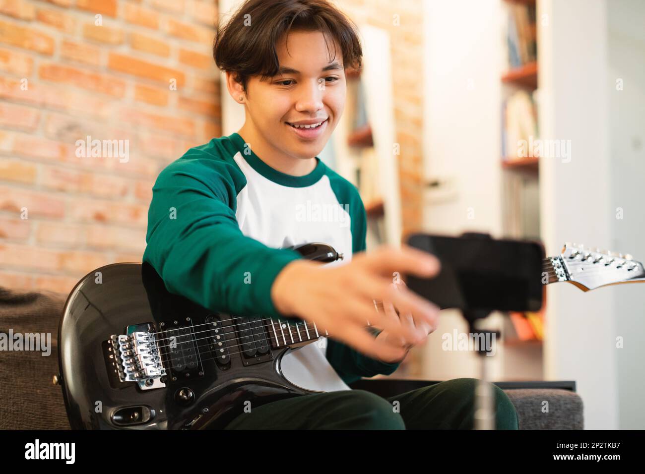 Korean Teen Boy jouant Guitar Shooting vidéo sur smartphone à l'intérieur  Photo Stock - Alamy