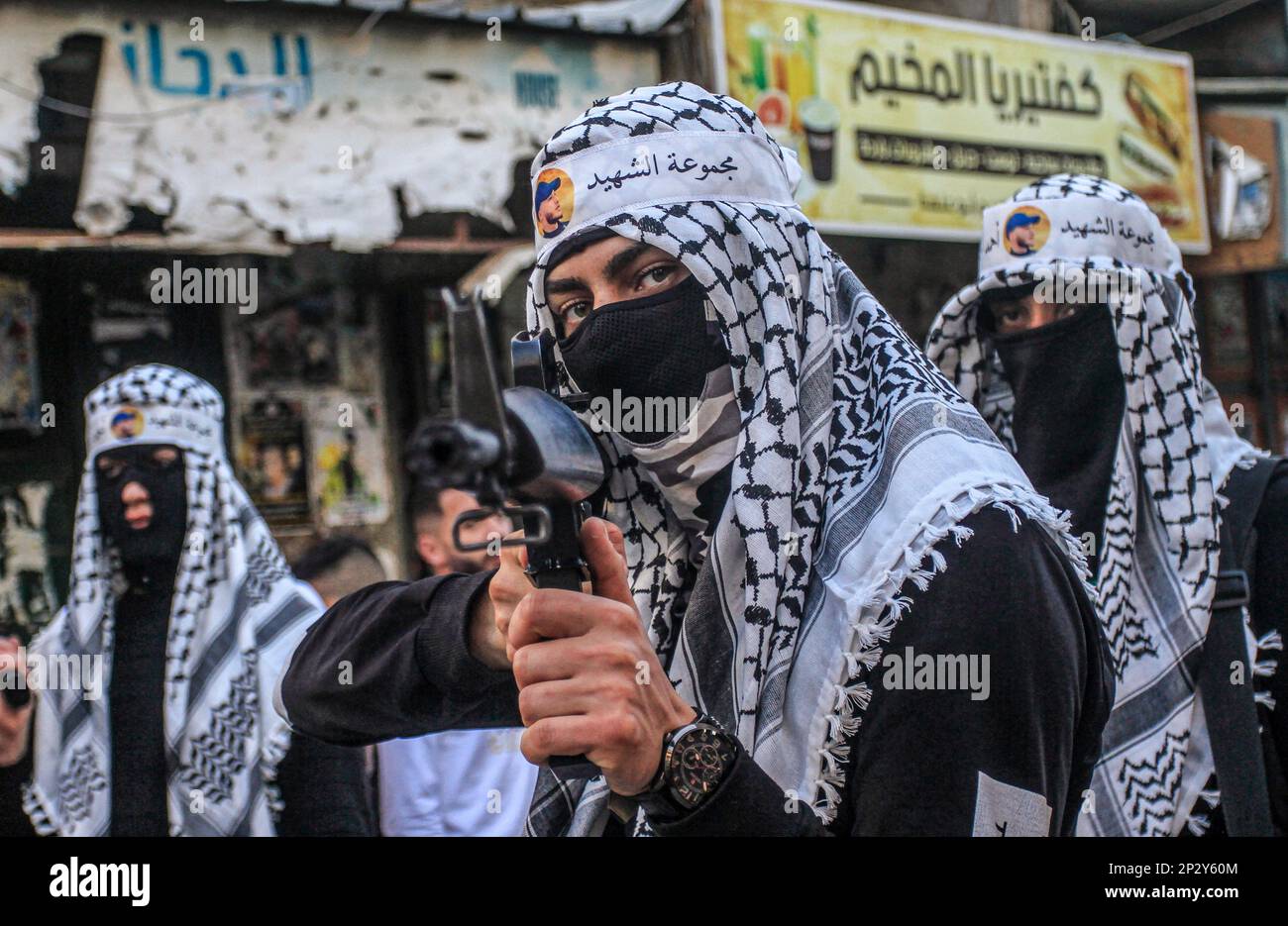 Naplouse, Palestine. 04th mars 2023. Un tireur palestinien masqué du bataillon de Balata tient son arme lors d'une cérémonie de commémoration pour deux Palestiniens qui ont été tués par l'armée israélienne il y a un mois, dans le camp de réfugiés de Balata, à l'est de Naplouse, en Cisjordanie. De nombreuses factions et militants palestiniens présentent leurs armes et leur force pendant toute la cérémonie de commémoration pour les Palestiniens qui sont tués par l'armée israélienne, afin de montrer l'étendue de leur force à l'armée israélienne. Crédit : SOPA Images Limited/Alamy Live News Banque D'Images