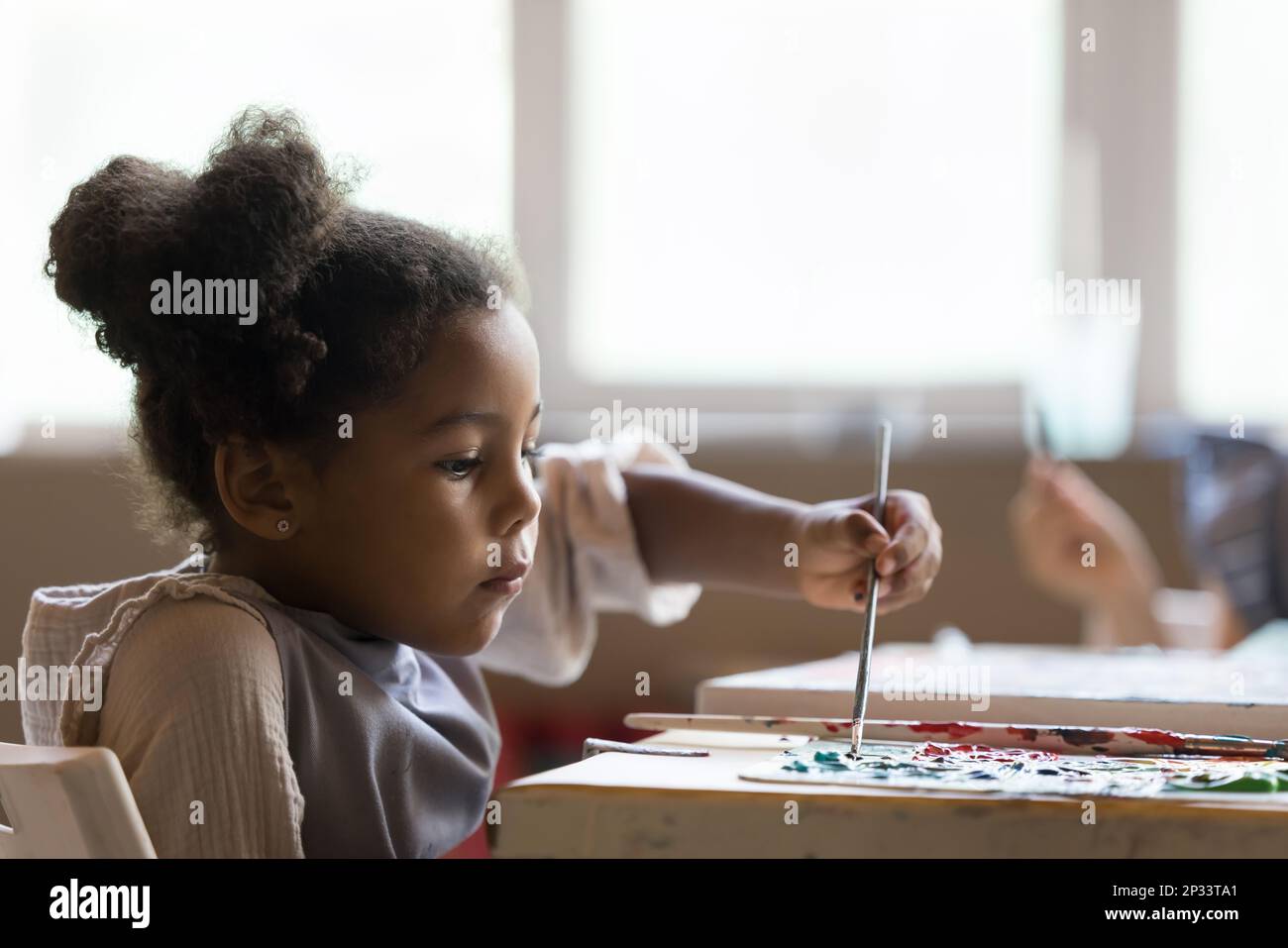 École artistique sérieuse African American pupille fille peinture sur toile Banque D'Images