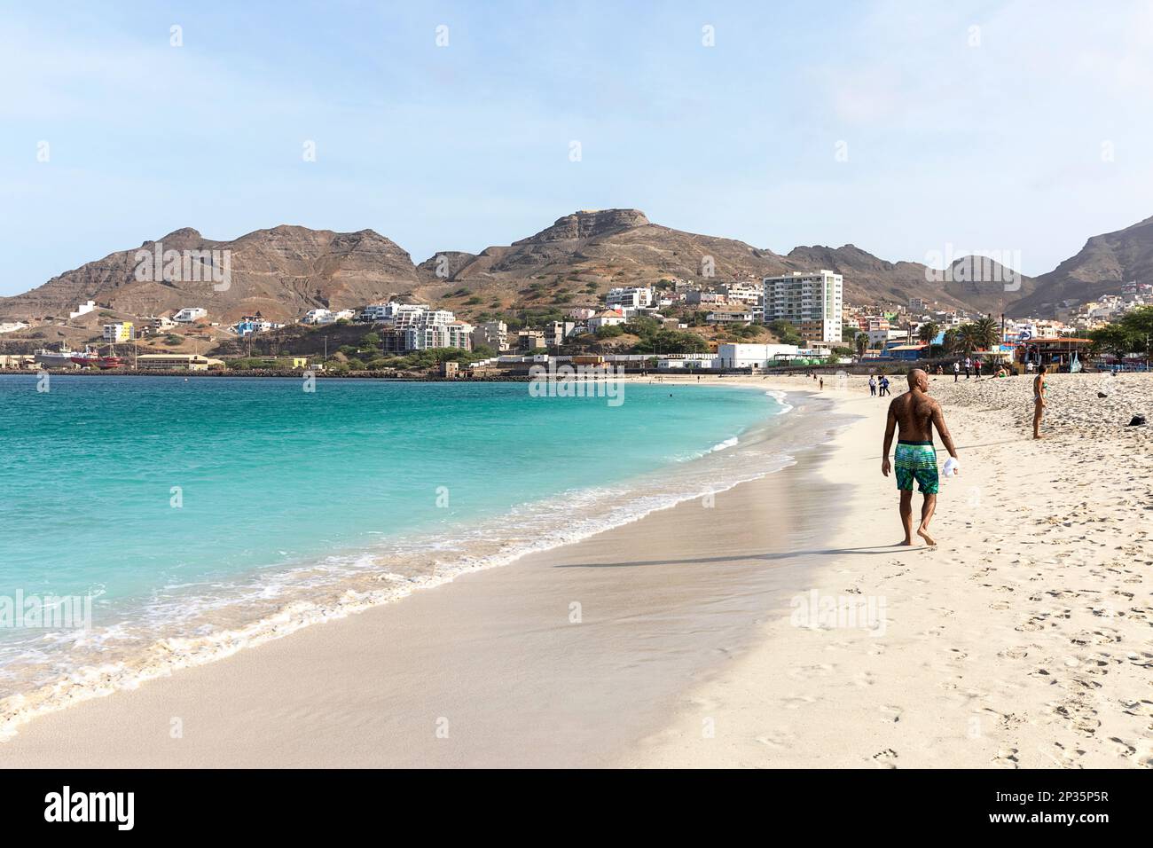 Les hommes marchent sur une belle plage de sable blanc Laginha dans le centre-ville de Mindelo lors d'une journée d'été parfaite sur l'île de Sao Vicente, Cabo verde Banque D'Images