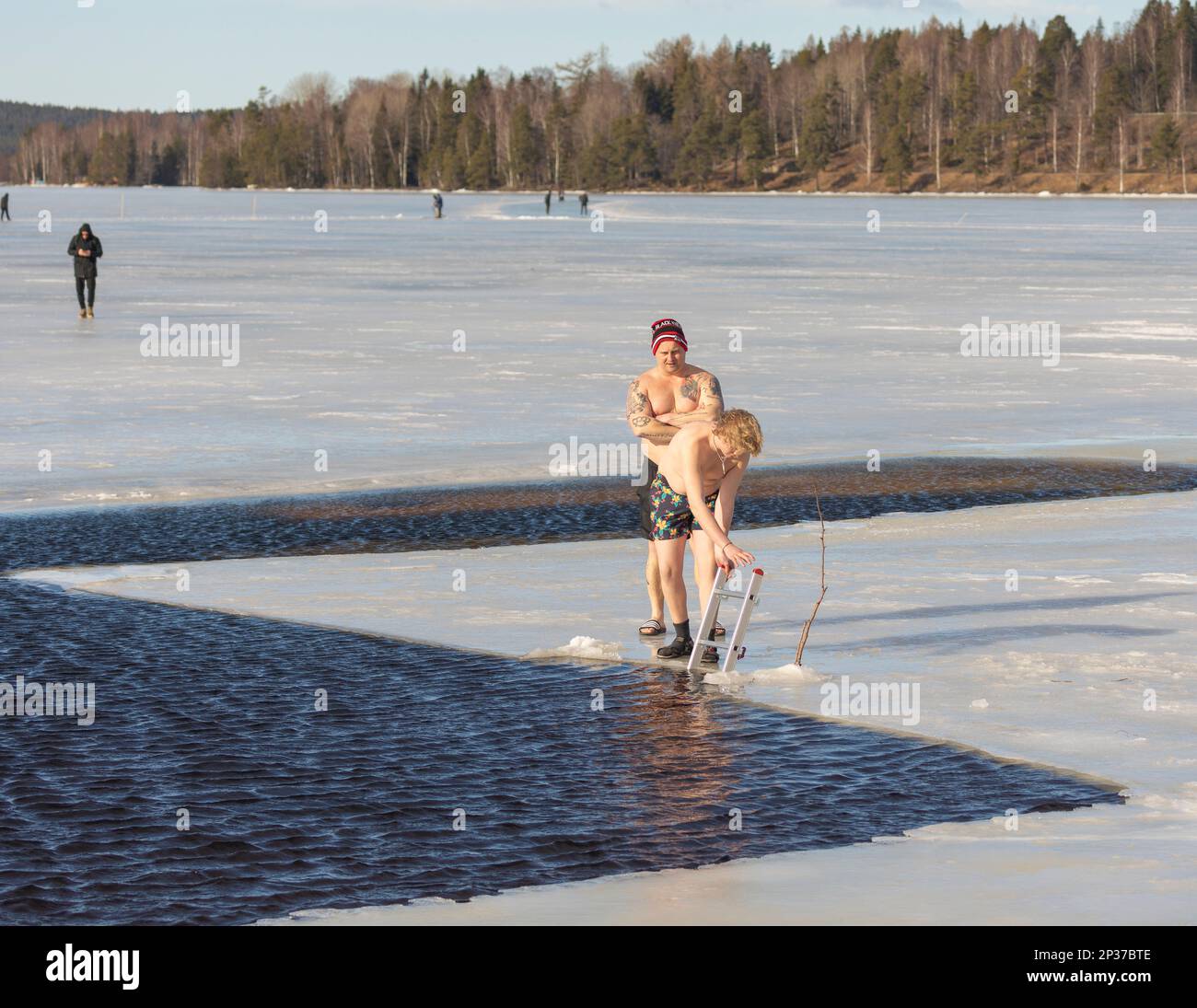 Fête annuelle d'hiver à Ludvika en Suède qui attire les gens à prendre un bain à 2 degrés Celsius, mais le soleil brille. Banque D'Images