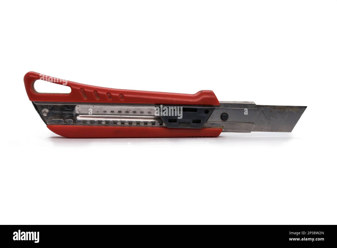 Utilisé couteau utilitaire à lame rétractable rouge avec lame sortie isolée sur fond blanc Banque D'Images