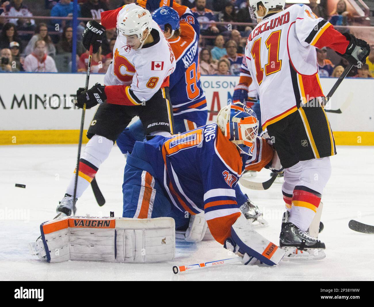 Calgary Flames' Joe Colborne (8) scores on Edmonton Oilers goalie Ben Scrivens (30) as Mikael Backlund (11) and Oscar Klefbom (84) watch during the first period of an NHL hockey game Saturday, April 4, 2015, in Edmonton, Alberta. (AP Photo/The Canadian Press, Amber Bracken) Banque D'Images