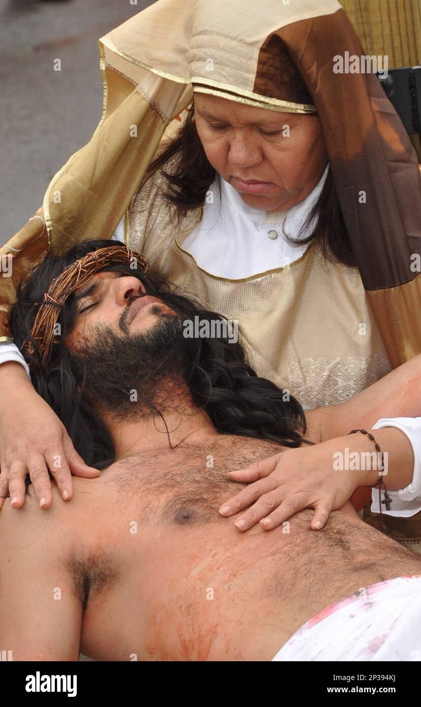 At the 13th station, Mary, portrayed by Martha Medina, holds in her arms her son Jesus, portrayed by Luis Arias, after he died and was taken down from the cross on Good Friday, April 3, 2015. Members of the Hispanic community at Holy Annunciation Church at Saint Gabriel Parish in Hazleton, Pa., walked a 2-mile trek throughout the city of Hazleton commemorating the Stations of the Cross. (AP Photo/Hazleton Standard-Speaker, Ellen F. O'Connell) Banque D'Images